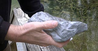 One of the rocks found in the spring vent that is not limestone and that the diver is keeping